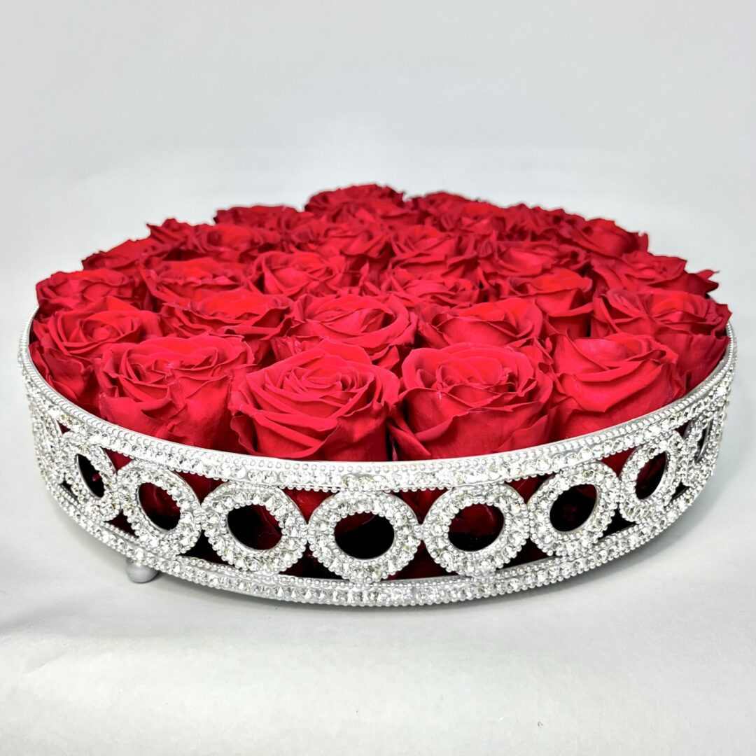 Round shaped silver basket full of red roses